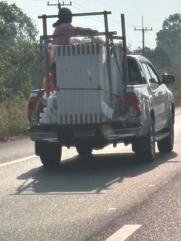 Zwei Arbeiter mit 18 Solarpaneelen auf dem Wagen