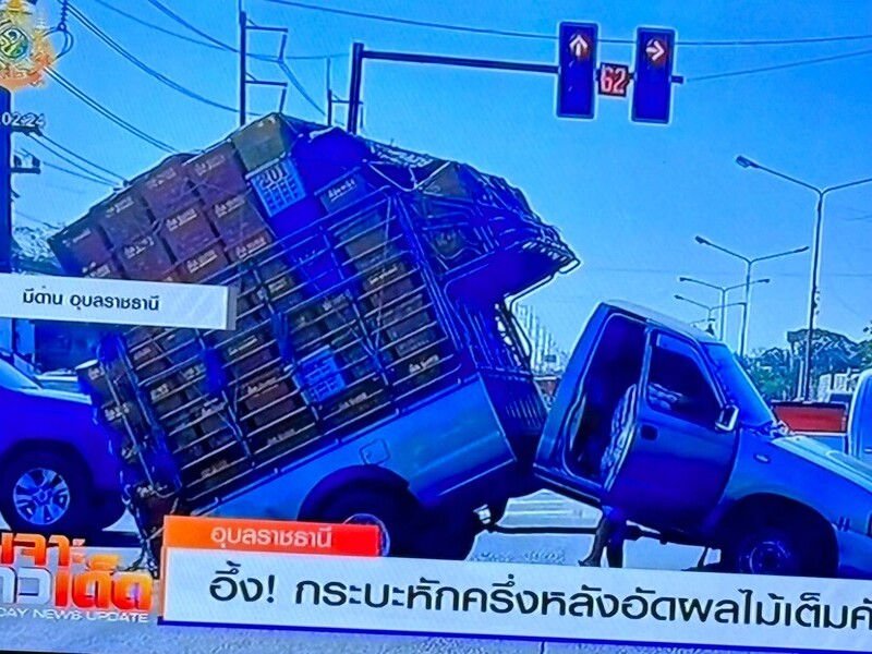 an overloaded car bent in the middle at a traffic light