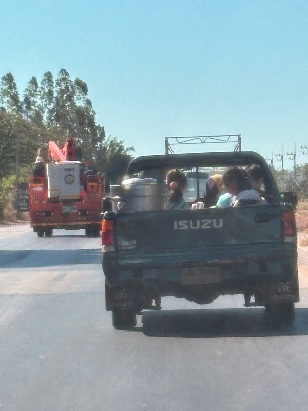 girls and a boy in the open air in warm weather on the back of the small truck